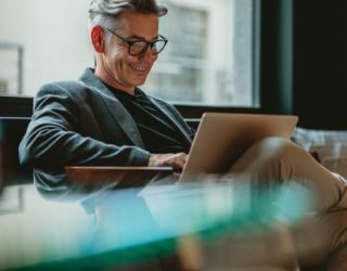 smiling man reading laptop